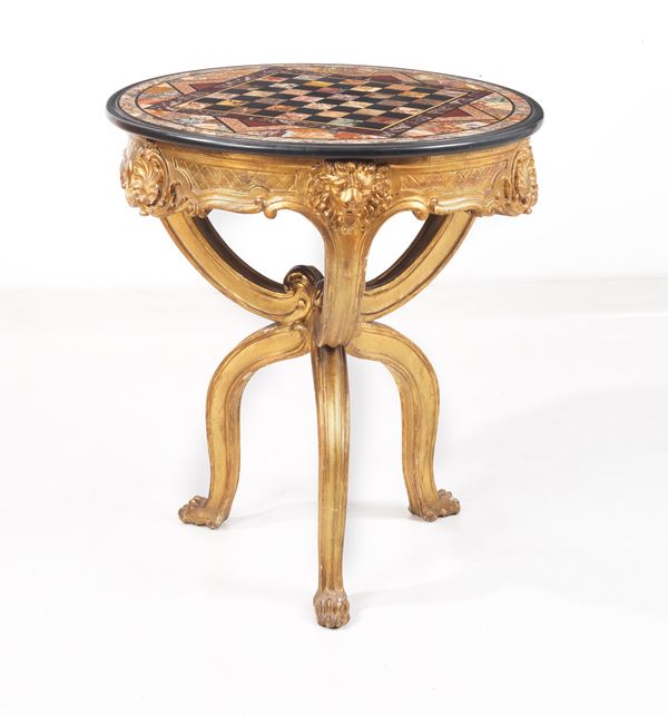 Ancient Roman round center table, in gilded wood and carved with lions&#39; heads motifs with intertwined legs, marble top with various inlays of precious marbles with central chessboard