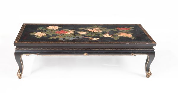 Chinese living room table in black lacquered wood with golden profiles, top entirely decorated with various polychromes with exotic flower and bird motifs, four curved legs