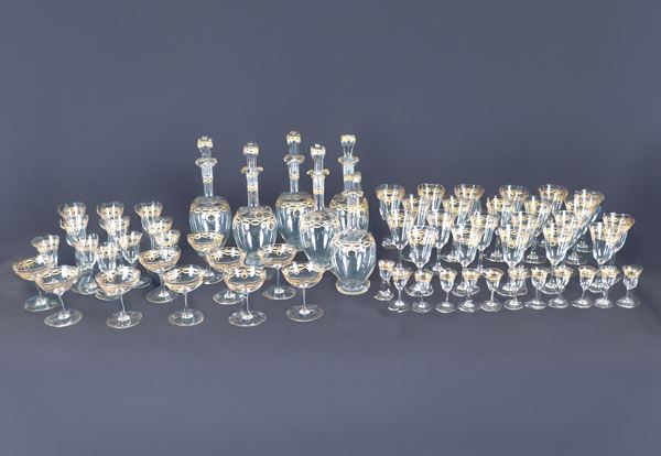 Antique crystal glass set, with pure gold decorations in Louis XVI motifs of bows and cords, consisting of: 11 water glasses, 11 white wine glasses, 5 red wine glasses, 6 dessert wine glasses, 10 champagne glasses, 12 rosolio glasses and four bottles, one of which is missing the cork (59 pcs.)