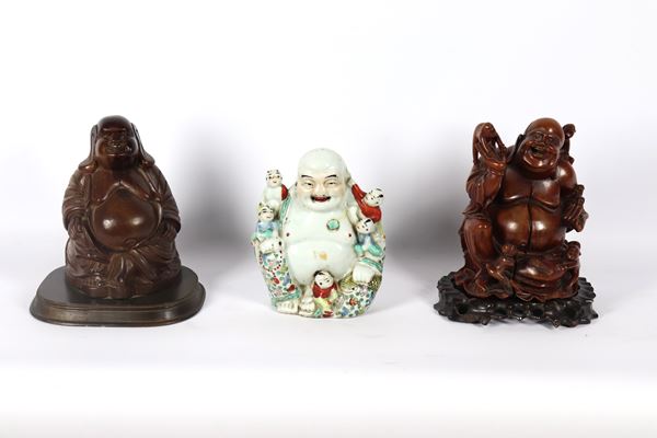 Lotto di tre Buddha cinesi, uno in porcellana policroma e due in legno