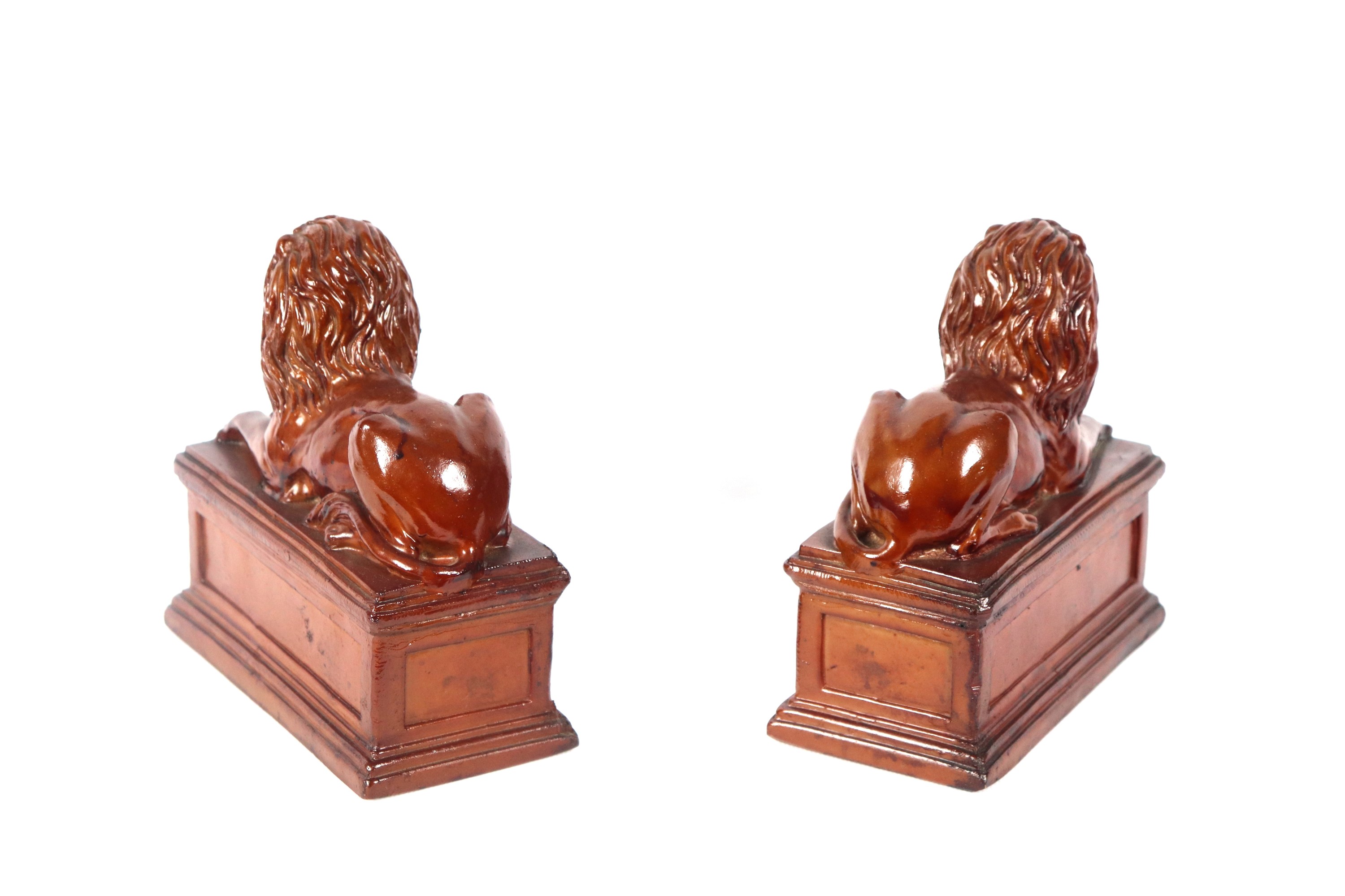 Coppia di fermalibri con sculture di leoni a finto legno patinato