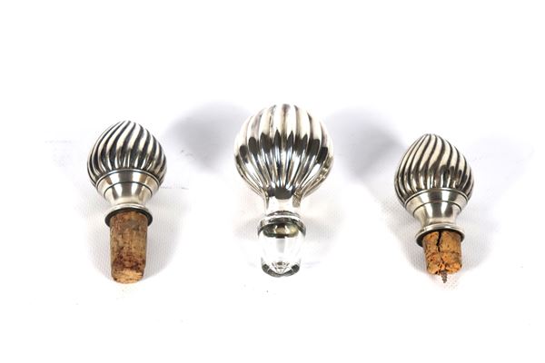 Lot of three wine bottle stoppers, covered in chiseled silver with pods