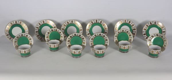 Antico servizio di sei piattini da dolce e sei tazze da tè con piattini in porcellana Richard Ginori, con decorazioni a motivi Impero di palmette dorate su fondo verde e bianco, (12 pz.). Un piattino presenta lieve sbeccatura nella parte sottostante del bordo