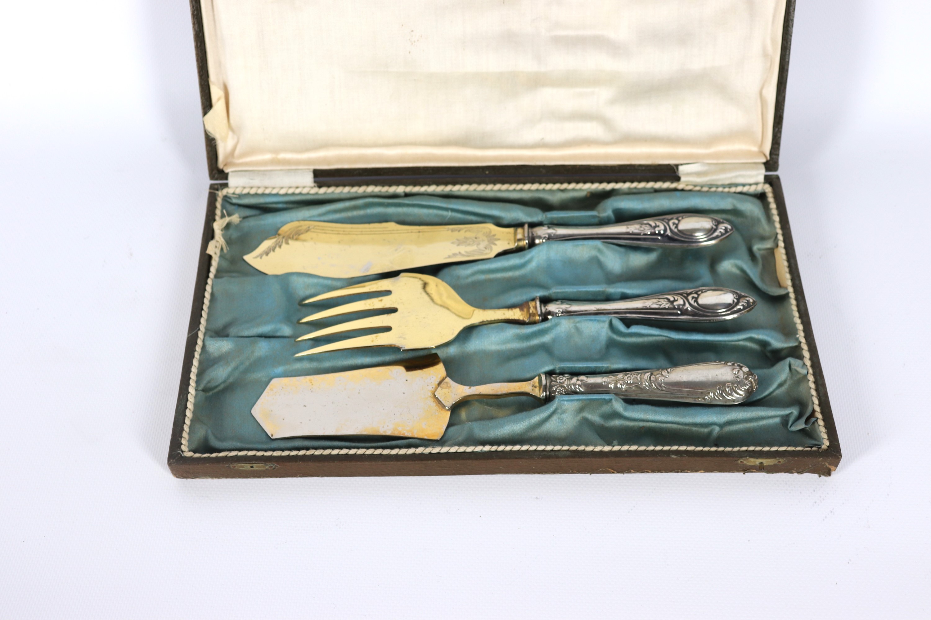 Lotto di tre posate da portata per dolce in vermeil con manici in argento cesellato e sbalzato, a...