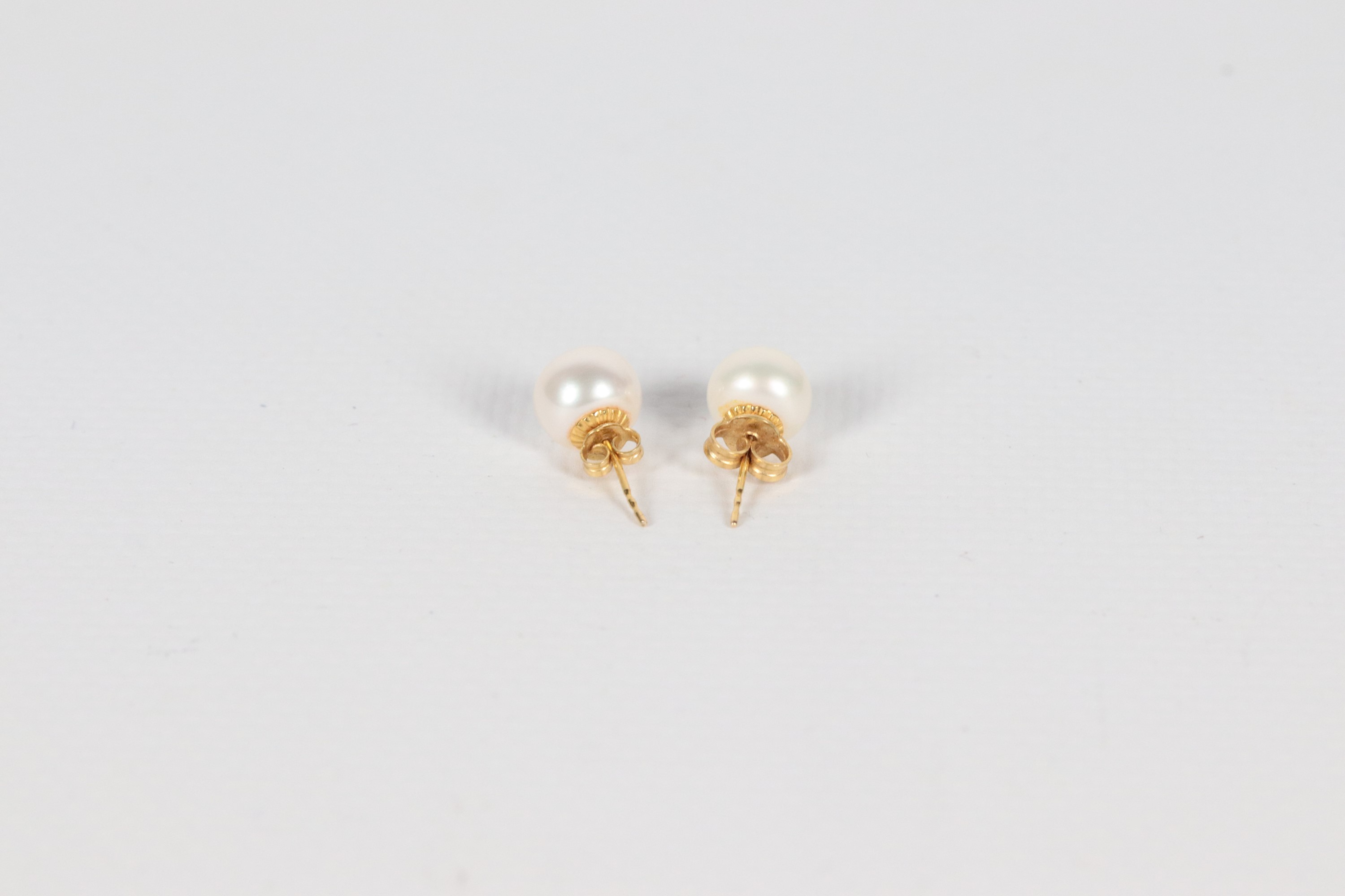 Orecchini a bottone con perle coltivate 8,5 mm, con perno e chiusura in oro giallo 18kt. Una farf...