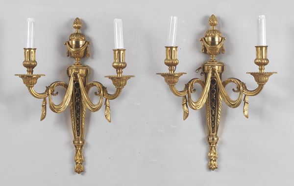 Pair of French wall lamps in gilded bronze, embossed and chiselled with Louis XVI motifs of bows and drapes, 2 lights each