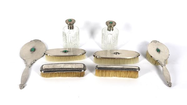 Antique dressing table set in chiseled and embossed silver, with applications of green stones, one of which is missing, and two different brushes (8 pieces)