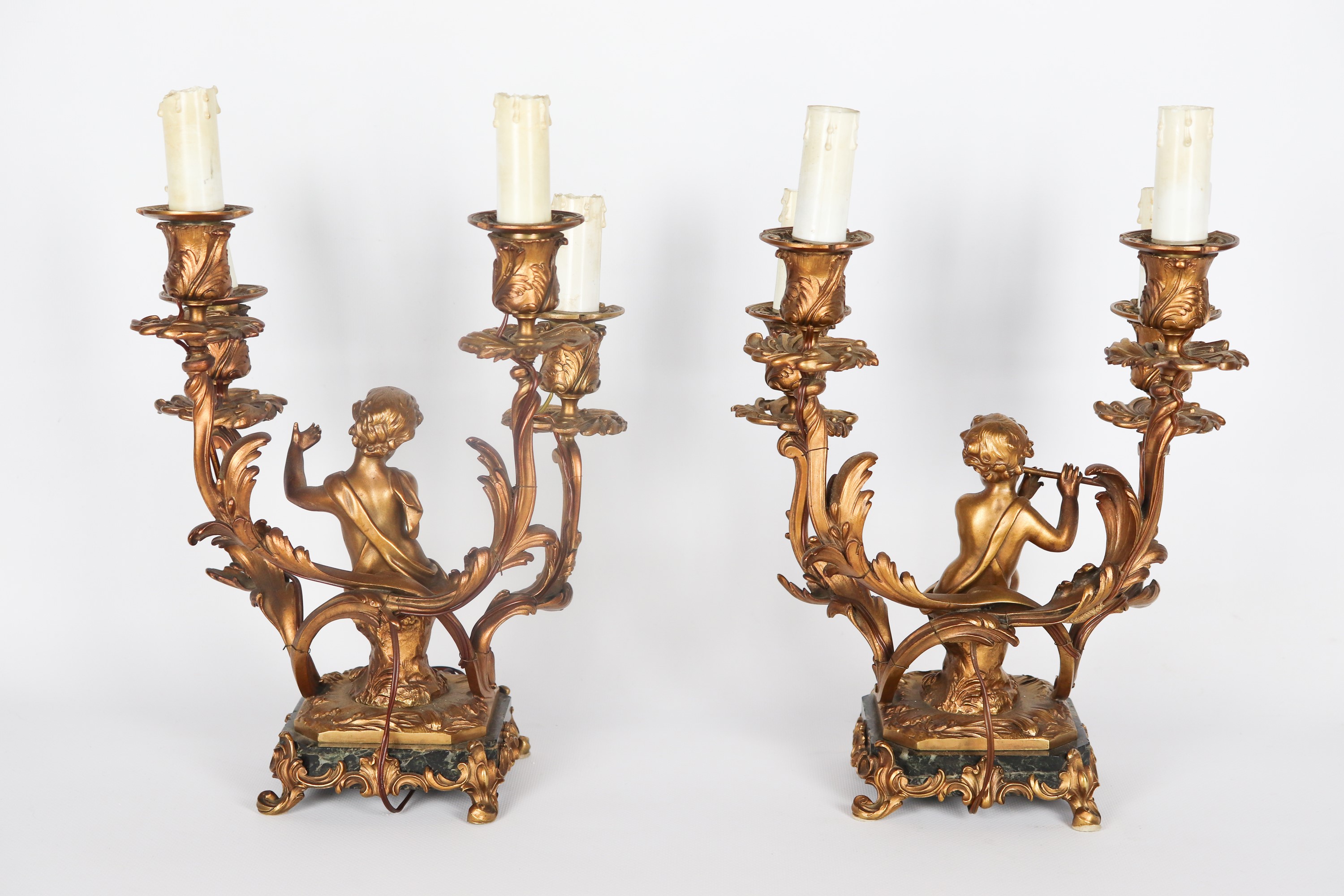 Coppia di antichi candelabri francesi in bronzo dorato, sbalzato e cesellato con sculture di putt...