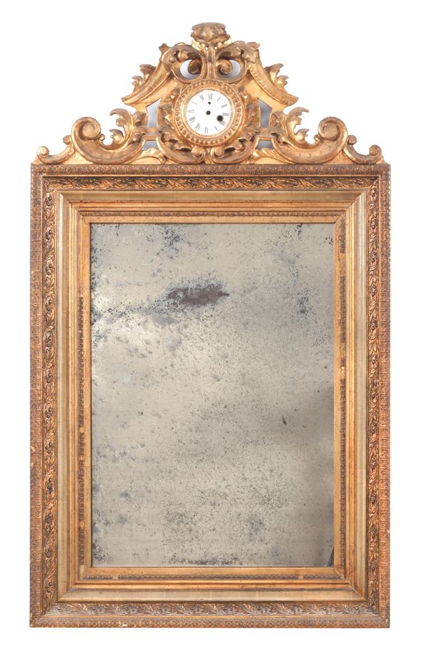 Antique French mirror in gilded and carved wood, with a frieze formed by curls and acanthus leaves, in the centre a clock with a white enamel dial missing the mechanism, mercury mirror