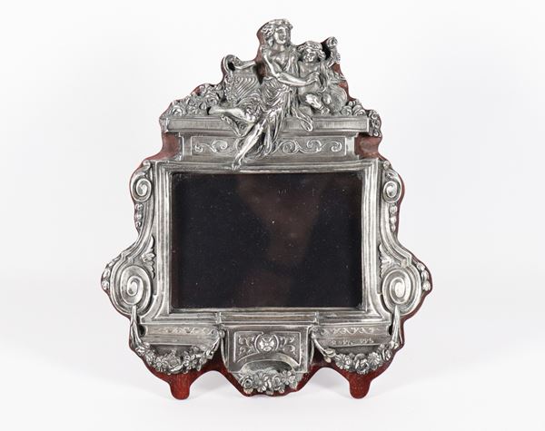 Table frame in silver Title 925, chiselled and embossed with Louis XVI motifs, on the top small sculptures of vestal and putto, wooden support