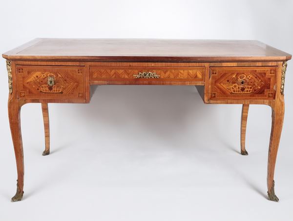 French rosewood and purple ebony center desk, with inlays of flower baskets and rosettes, friezes and fittings in gilded and chiselled bronze, three drawers, two sliding lateral shelves and four curved legs