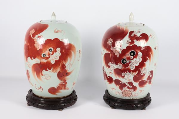 Pair of polychrome enamel vases depicting Pho dogs and inscriptions, with teak bases. China, Qing Dynasty, 19th century