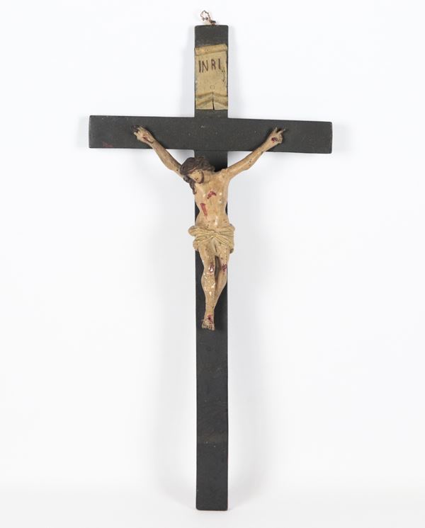 Antique crucifix in lacquered and polychromed papier-mâché. Slight defects and some missing parts