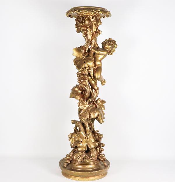 Gilded and carved wooden vase holder column, with sculpture of a cherub celebrating and intertwining of vine leaves and bunches of grapes