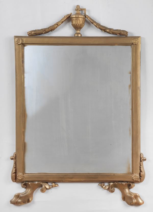 Antique mirror in gilded and carved wood, with a cymatium with laurel cord motifs with an amphora, the lower part ending with two lion&#39;s paws