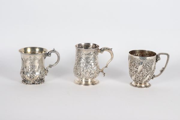 Lot of three small antique silver jugs, chiselled and embossed with floral and fruit scroll motifs, different shapes and sizes, 495 gr.