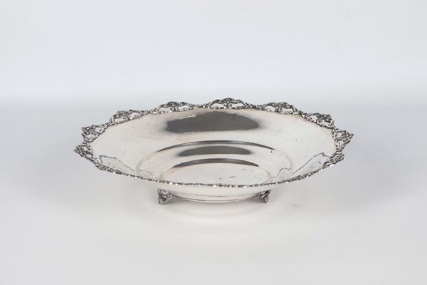 Centrotavola tondo in argento, on bordo cesellato, sbalzato e traforato, sorretto da tre piedini ricurvi, gr.250