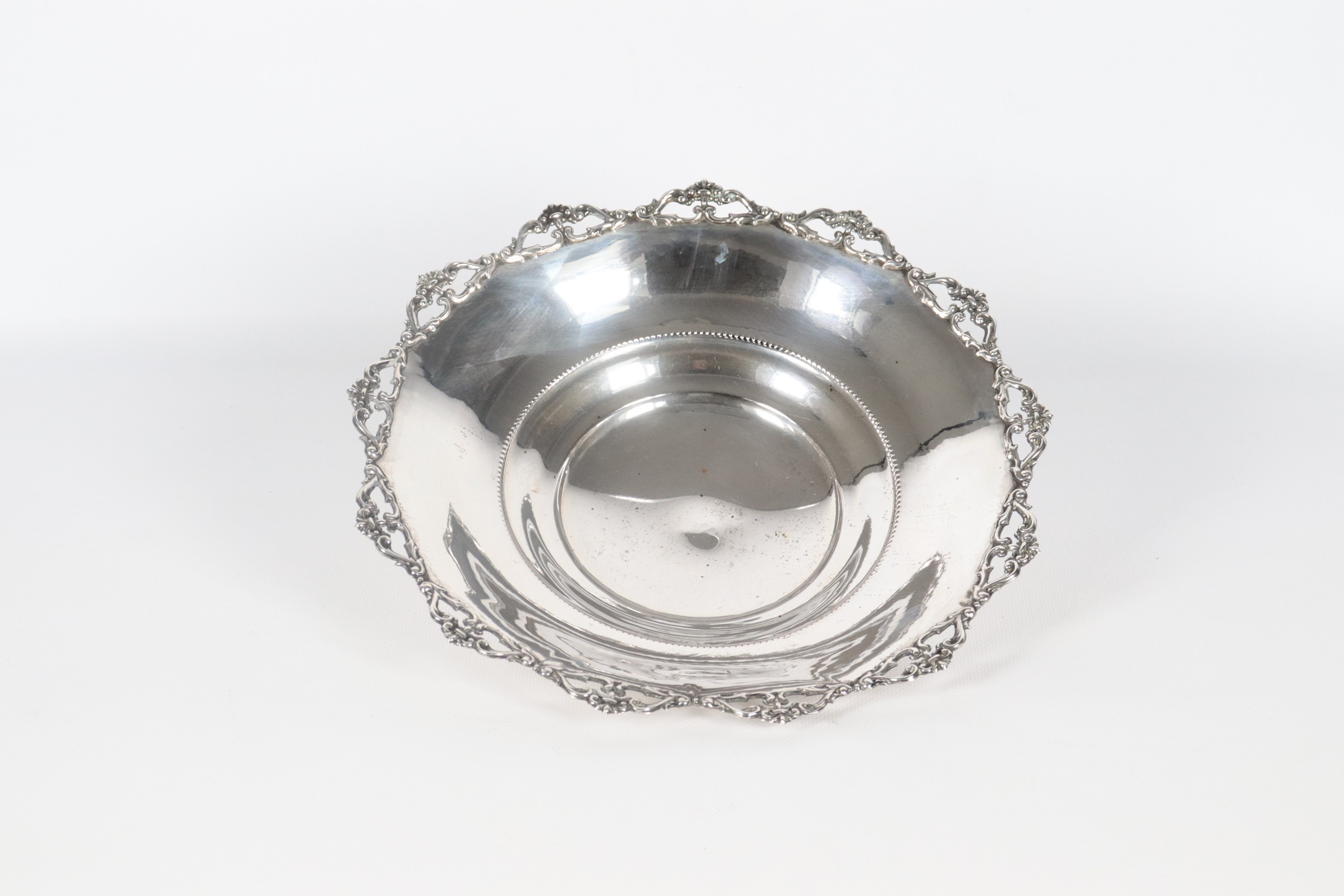 Centrotavola tondo in argento, on bordo cesellato, sbalzato e traforato, sorretto da tre piedini ...