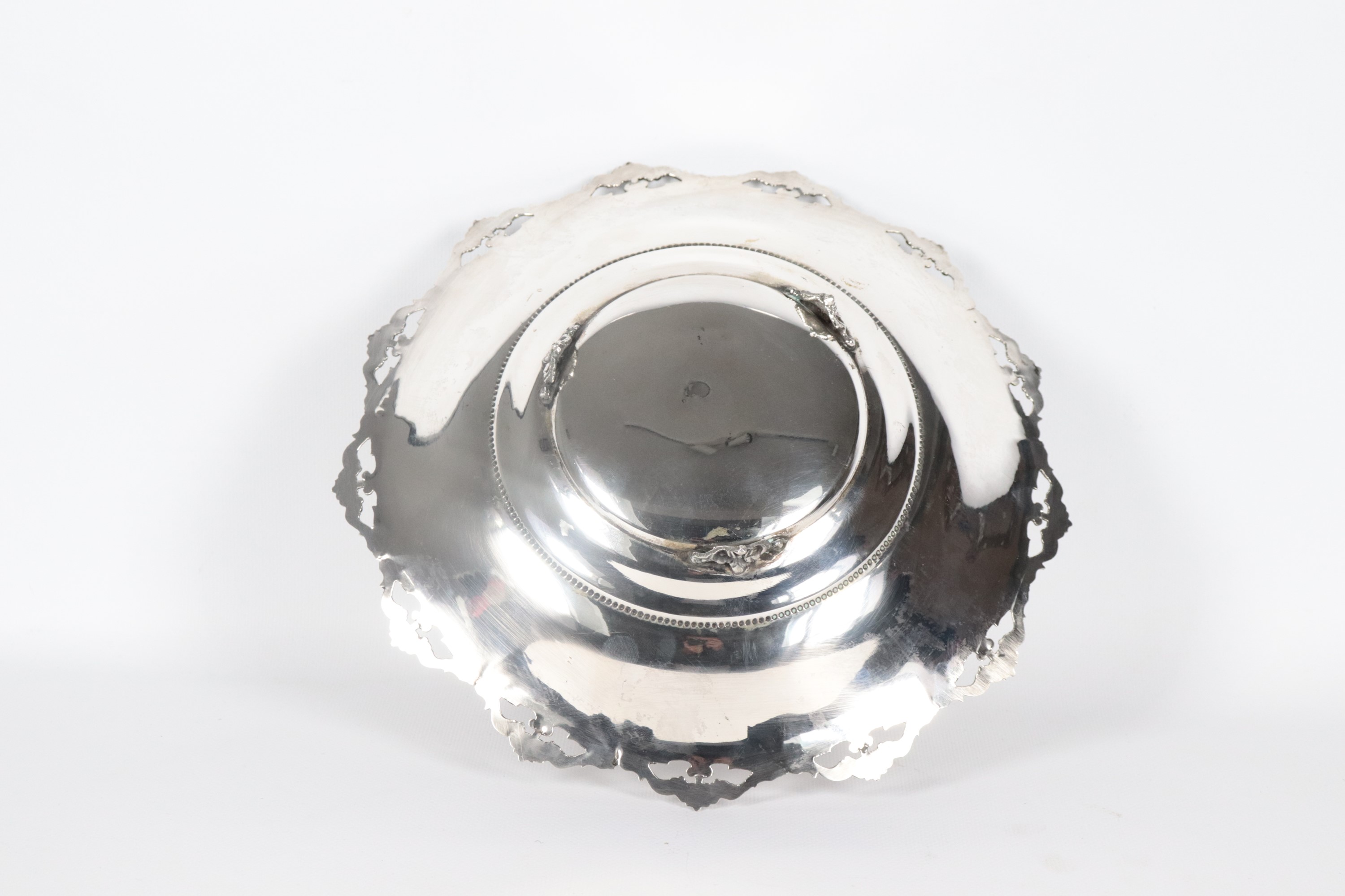 Centrotavola tondo in argento, on bordo cesellato, sbalzato e traforato, sorretto da tre piedini ...