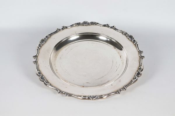 Centrotavola tondo in argento con bordo centinato, cesellato e sbalzato a motivi di volute e conchiglie marcato Frugoni, gr. 420