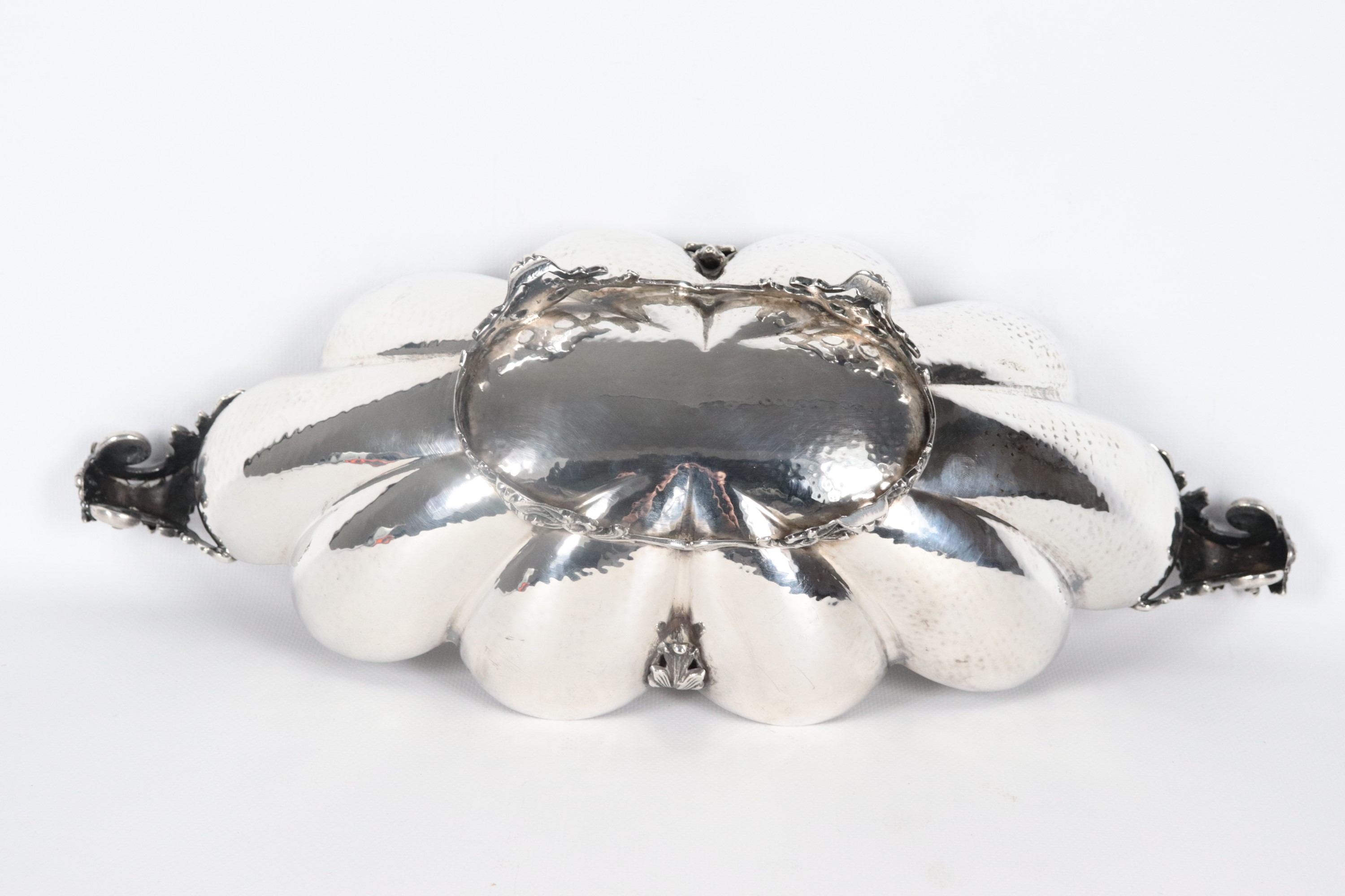 Centrotavola a barchetta in argento cesellato e sbalzato, con bordo centinato e sorretto da quatt...