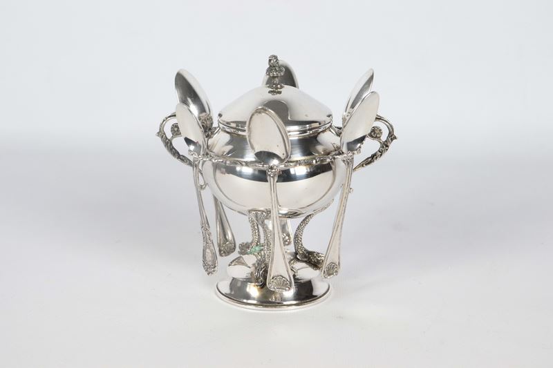 Zuccheriera in argento a forma di anfora con sei cucchiaini, sorretta da tre piccole sculture di ...