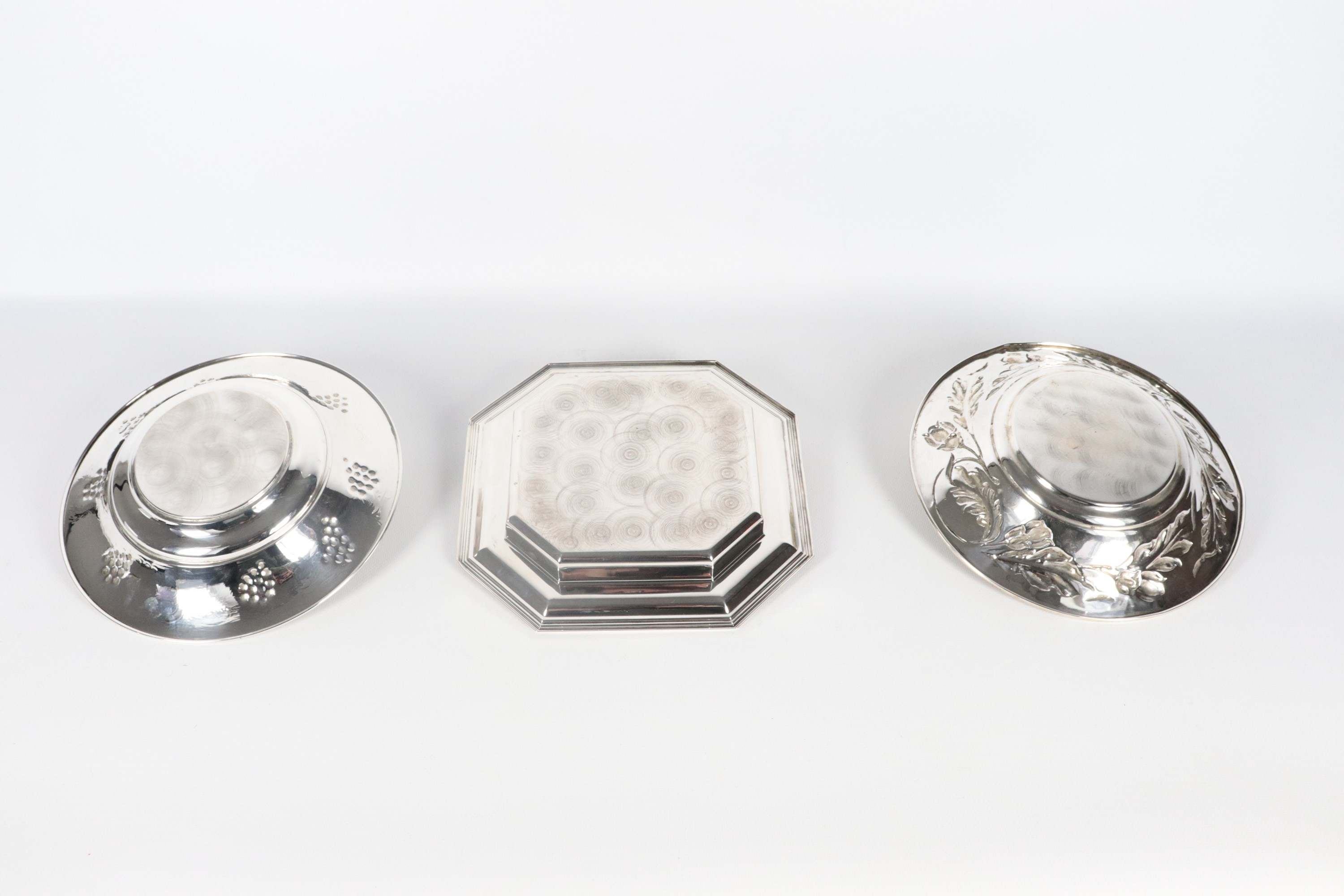 Lotto in argento cesellato e sbalzato di due centrotavola tondi e uno ottagonale (3 pz.), gr. 790