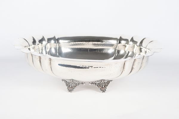Oval centrepiece in chiseled and embossed silver, with arched edge and supported by four curved feet, gr. 1240