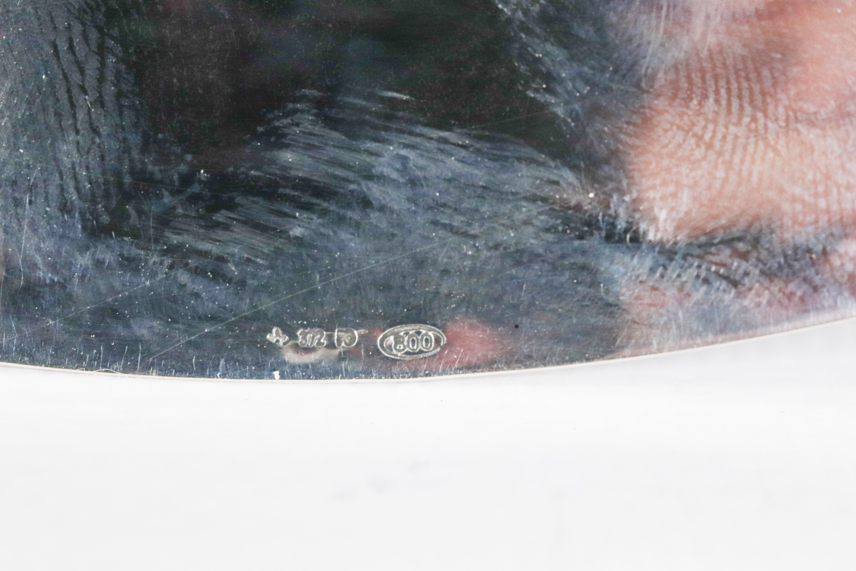 Centrotavola ovale in argento cesellato e sbalzato, con bordo centinato e sorretto da quattro pie...