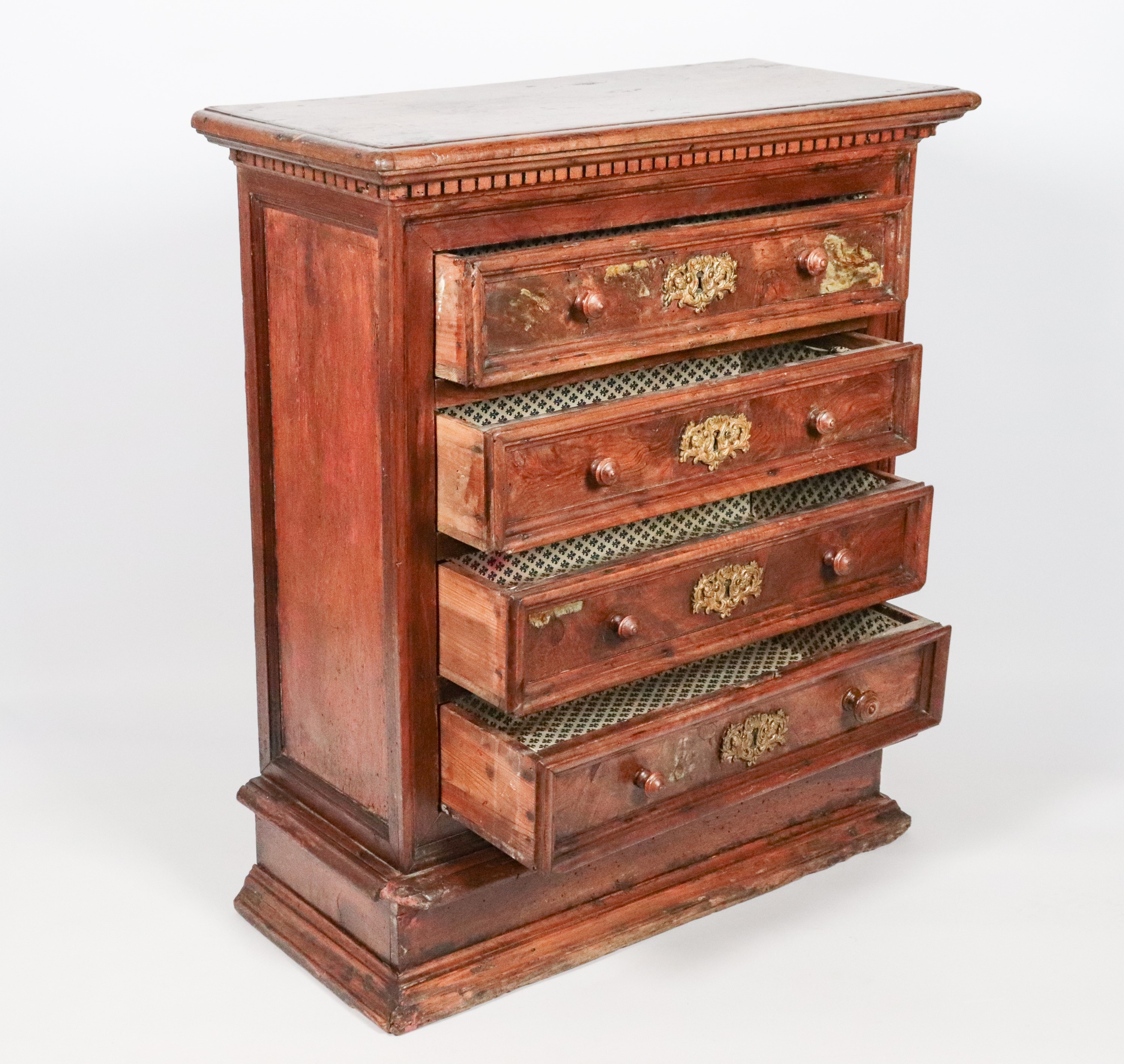 Antico comodino romano in noce, a quattro tiretti con bocchette in bronzo dorato e cesellato. Dif...