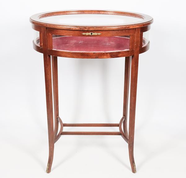 Oval center table in mahogany, with fold-down top and four curved legs joined by a crosspiece
