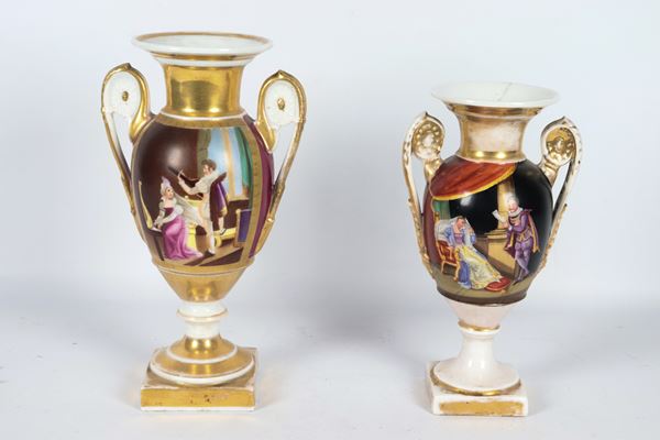 Lot of two antique French Empire porcelain vases, with colorful gallant scenes and highlights in pure gold, different sizes. The vases have slight hairlines inside the neck.