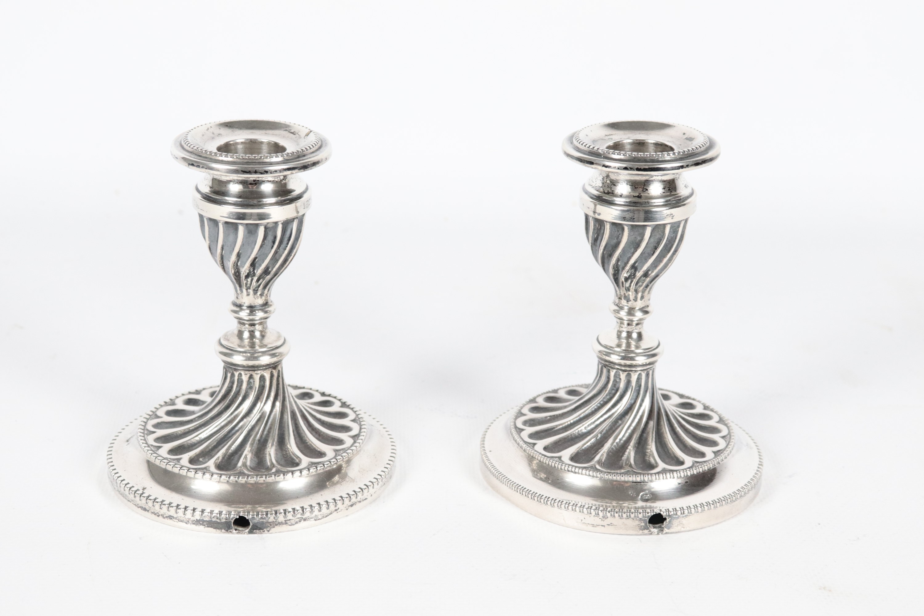 Coppia di portacandele in argento cesellato e sbalzato, gr. 280