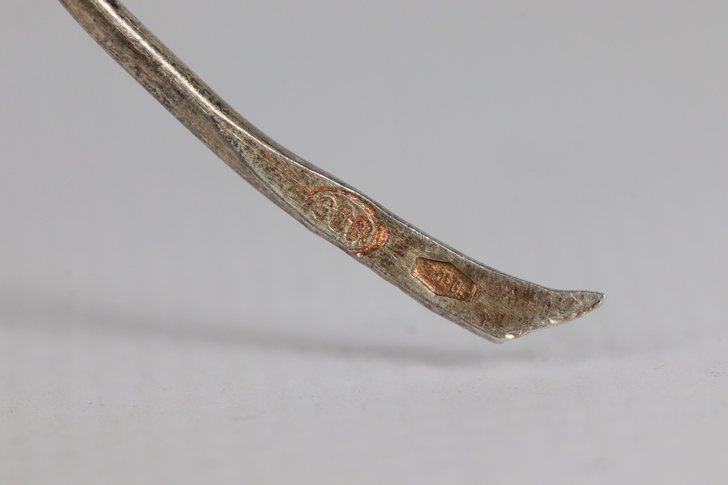 Lotto di due spille in argento filigranato e smalti, una a motivo di foglie e fiore una con volto...