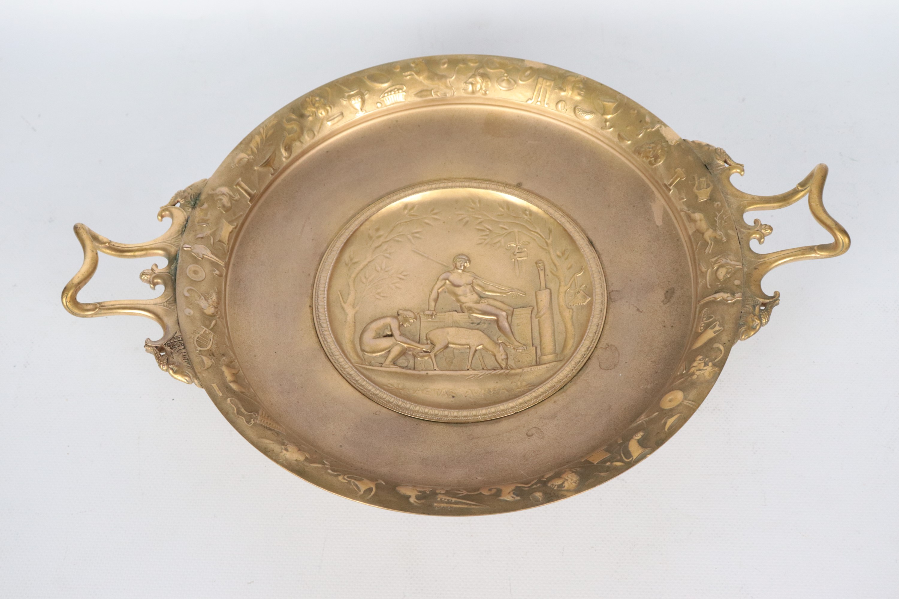 Firmata. "Aetas aurea", alzata in bronzo dorato e cesellato con medaglione centrale lavorato ad a...