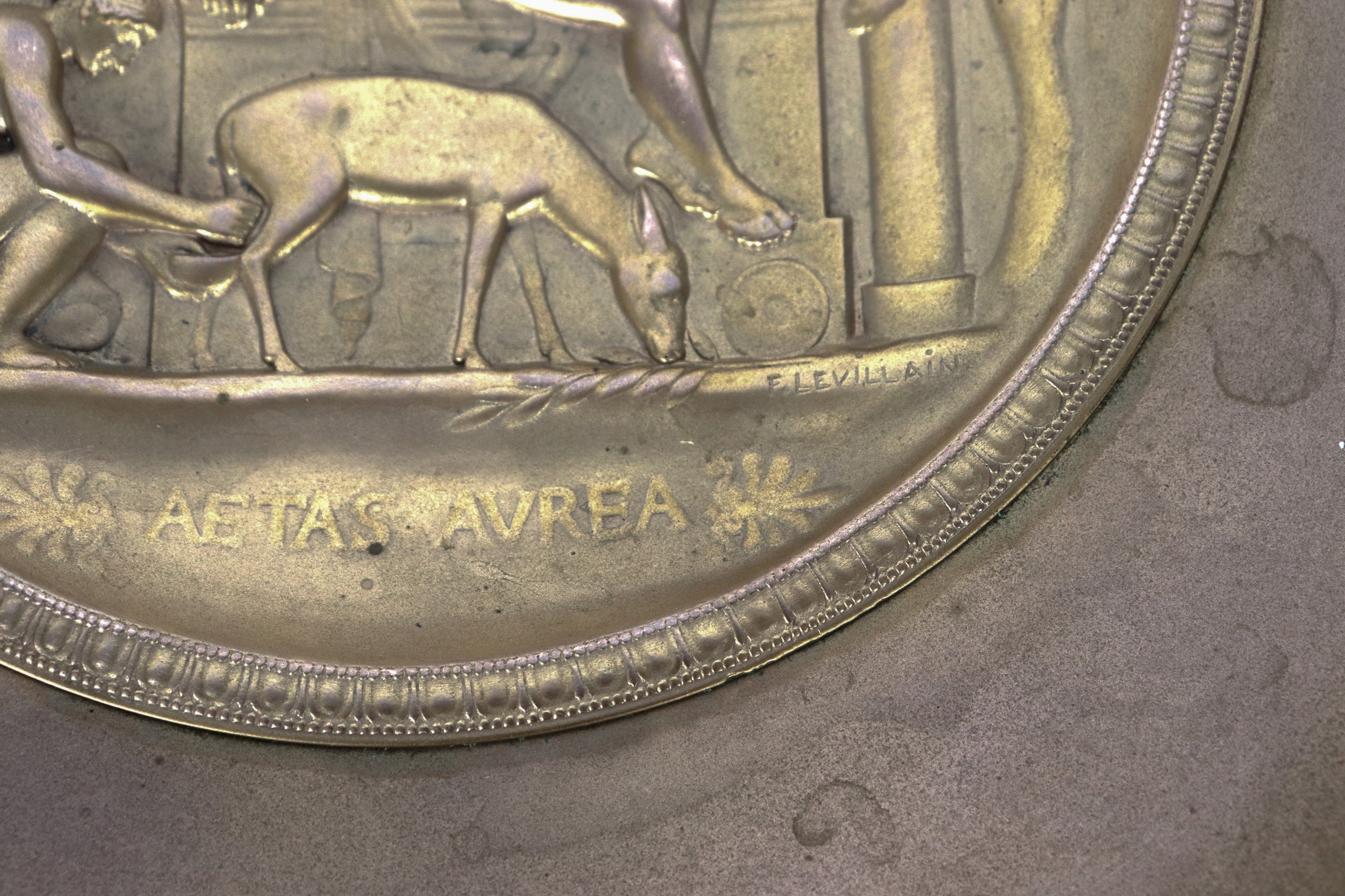 Firmata. "Aetas aurea", alzata in bronzo dorato e cesellato con medaglione centrale lavorato ad a...
