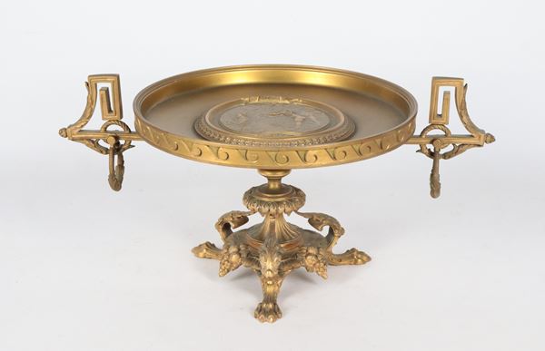 Antica alzata francese Napoleone III in bronzo dorato, cesellato e sbalzato, con medaglione raff.nte "Baccanale di putti", sorretta da base con grappoli d'uva e tre gambe leonine