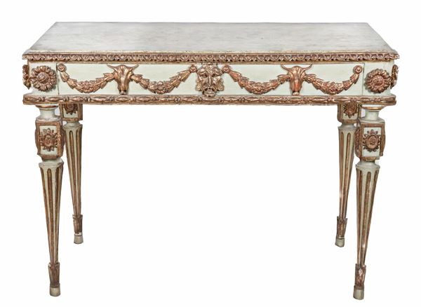 Antique Emilian Louis XVI console table in green lacquered wood, with gilded carvings in relief with floral garland motifs, mask and goat heads, four fluted legs and top decorated with fake marble