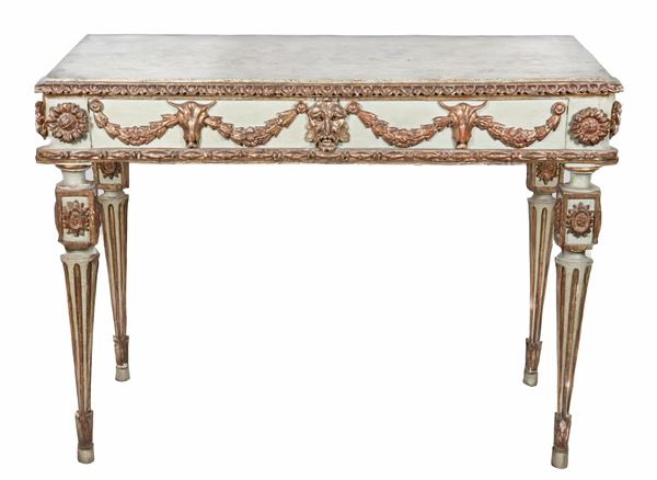 Antica consolle emiliana Luigi XVI in legno laccato verde, con intagli dorati a rilievo a motivi di ghirlande floreali, mascherone e teste caprine, quattro gambe scannellate e piano decorato a finto marmo