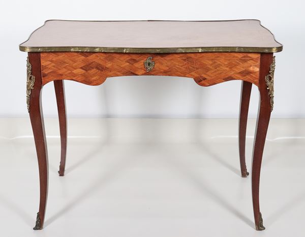 Antica piccola scrivania francese da centro in mogano, bois de rose ed ebano viola, a forma rettangolare centinata con un tiretto centrale, guarnizioni in bronzo dorato e quattro gambe ricurve
