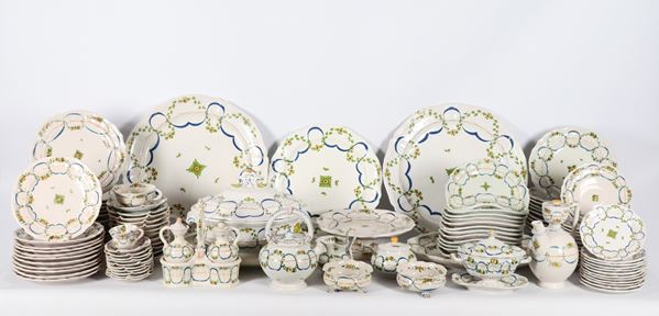Servizio di piatti in maiolica Cantagallo .- Firenze, con decorazioni policrome a motivi di ghirlande floreali e cordoni blu intrecciati, varie sbeccature (127 pz.)