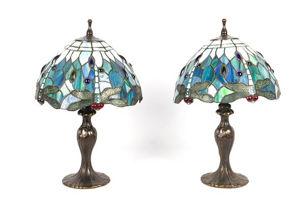 Coppia di piccole lampade di linea Liberty, in bronzo brunito con paralumi policromi in pasta di vetro