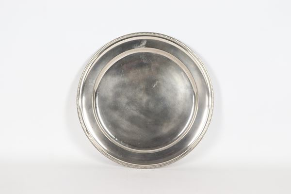 Grande piatto tondo da portata in argento, con bordo cesellato e sbalzato a motivi di palmette, gr. 770