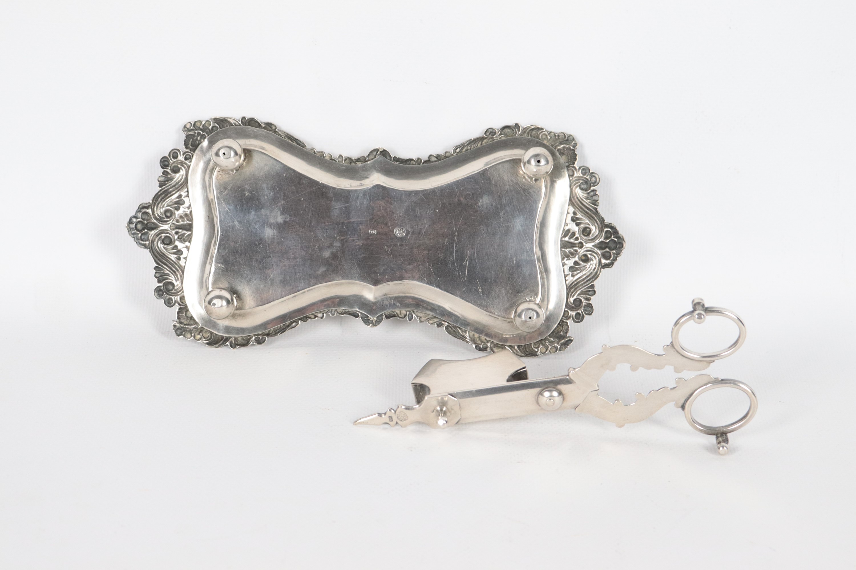Antico spegnicandele in argento cesellato e sbalzato, forbice e vassoietto sagomato, gr. 276. Bol...