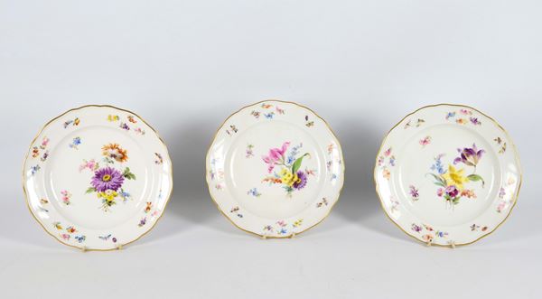 Antico lotto in porcellana Meissen di tre piattini da dolce, con decorazioni policrome a motivi di mazzetti di fiori, farfalle e insetti. XIX Secolo