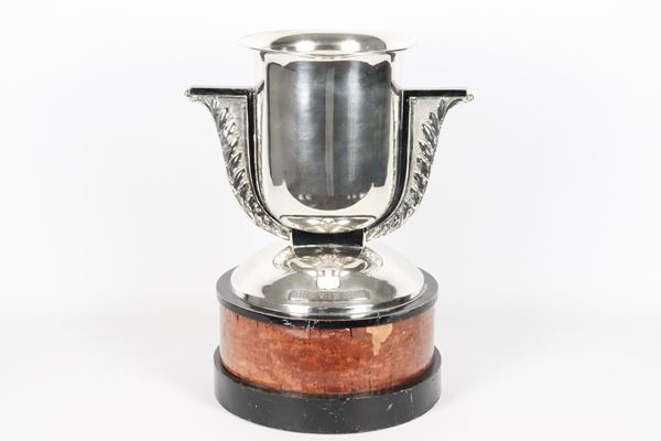 Silver trophy cup with chiseled and embossed handles and white enamel coat of arms, wooden base. Dated 1936, net weight of silver gr. 1600