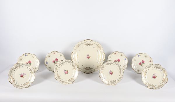 Servizio di piatti da frutta in porcellana tedesca di Bavaria, con decorazioni variopinte a motivi di mazzetti di fiori e ghirlande dorate, composto da fruttiera e otto piattini (9 pz.). Manifattura inizio XX Secolo