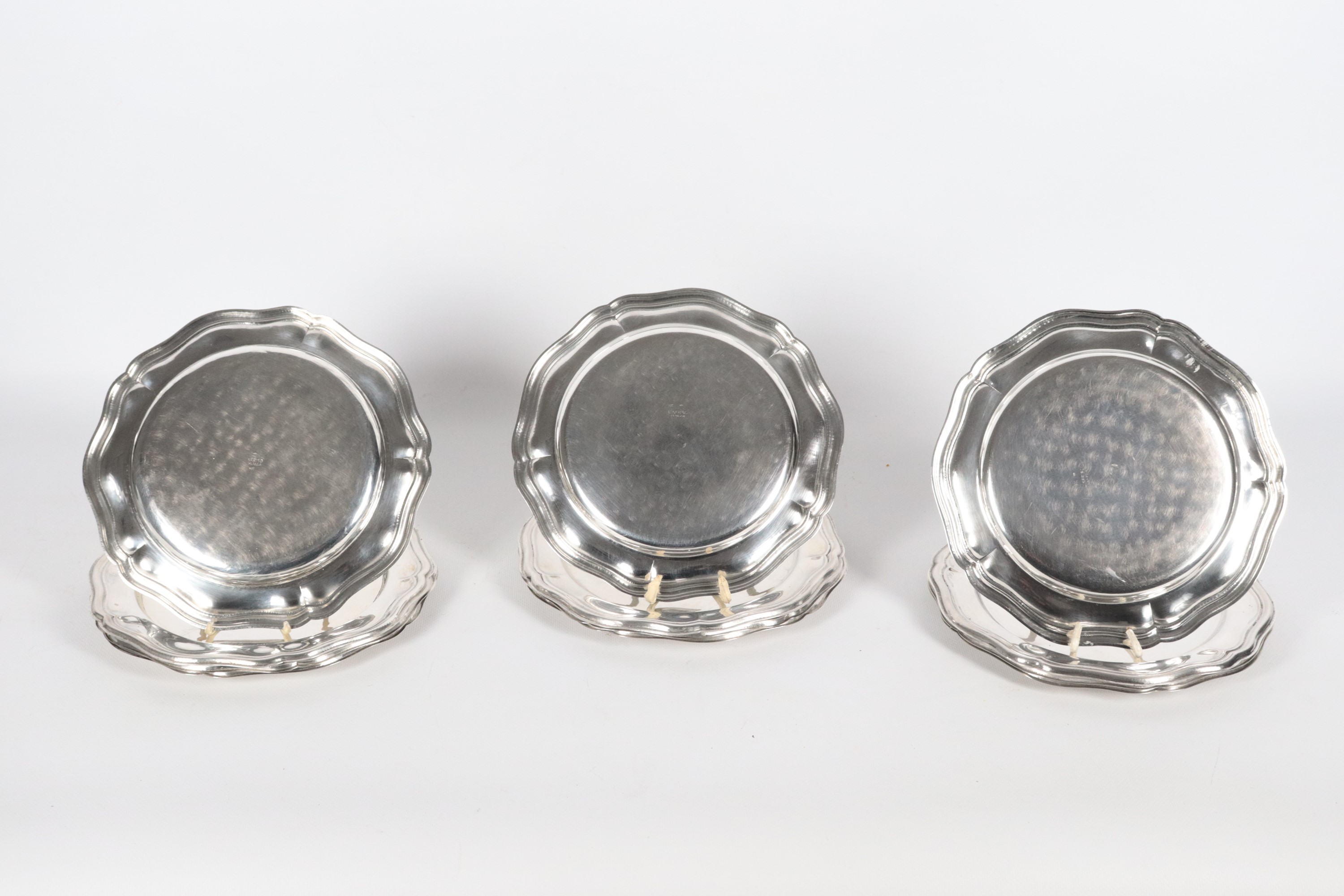 Lotto di dodici piccoli piatti tondi in argento, con bordo sbalzato e centinato, marcati L. Sfris...