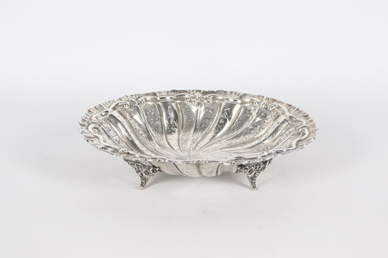 Antico piccolo centrotavola in argento a forma ovale, interamente cesellato e sbalzato a volute v...