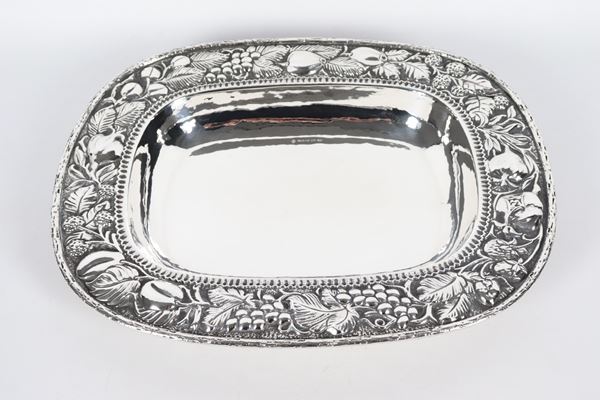 Large rectangular fruit bowl in silver with edge entirely chiseled and embossed with leaf and fruit motifs, marked Braganti - Florence, gr. 910